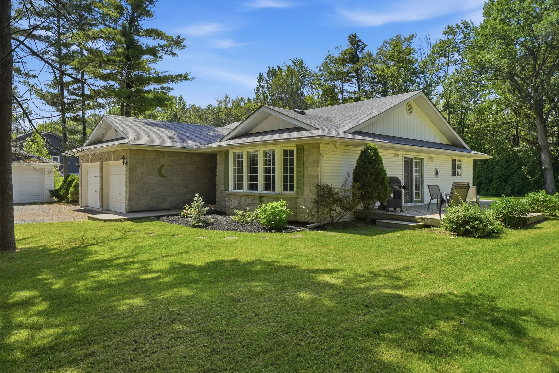 Exterior of 21627 Loyalist Parkway bungalow on a private treed lot in Carrying Place, Prince Edward County