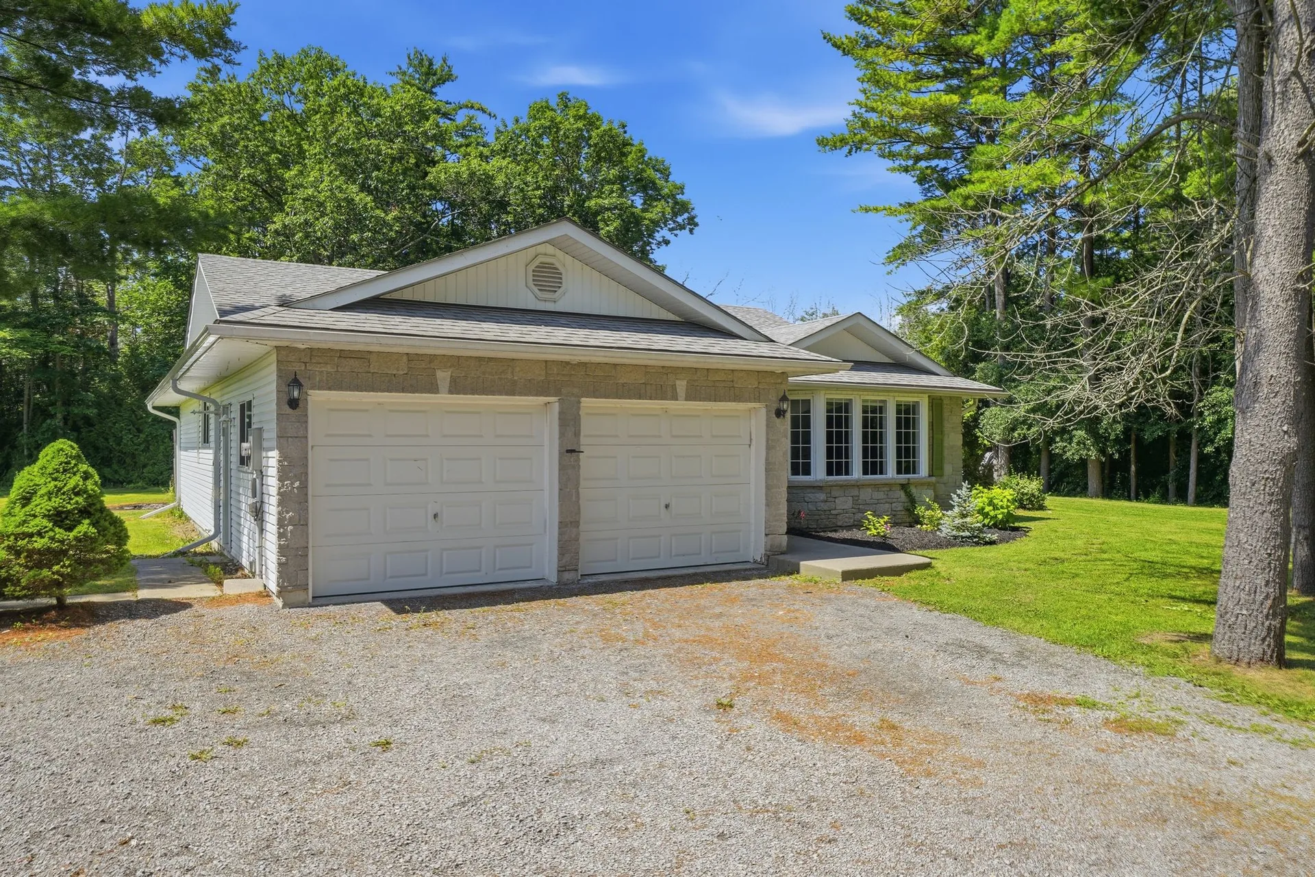 Attached two-car garage and gravel driveway at 21627 Loyalist Parkway, Prince Edward County