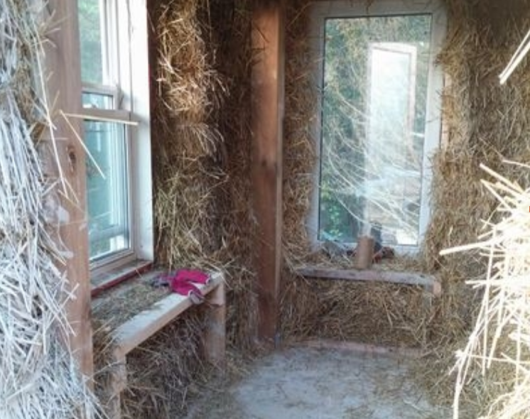 Stuffing straw into the gaps between bale courses