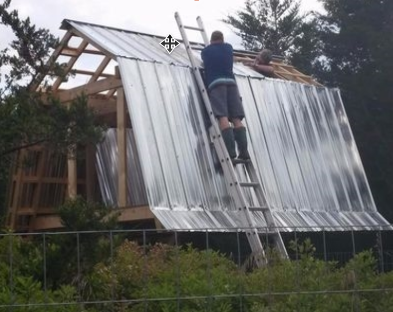 Installing the metal roofing panels on the gambrel roof frame